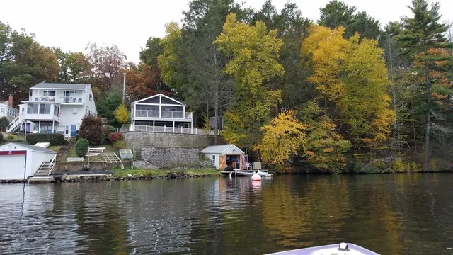 a view of house next to lake and trees