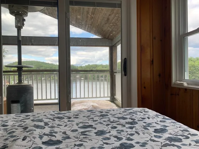 a bedroom with a bed and a large window