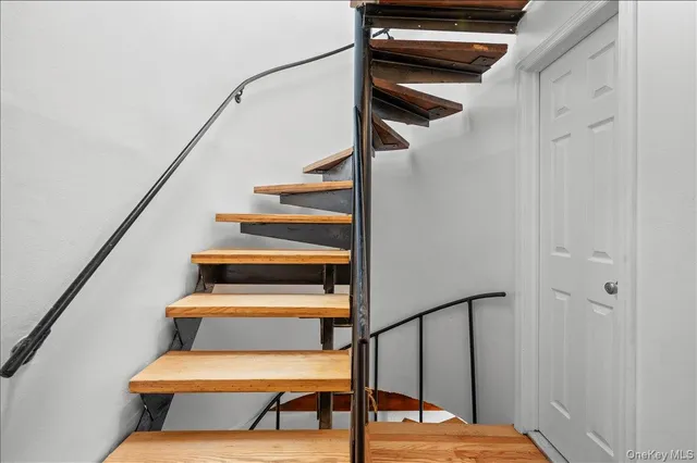 a bedroom with a bed a flat tv screen and a dresser