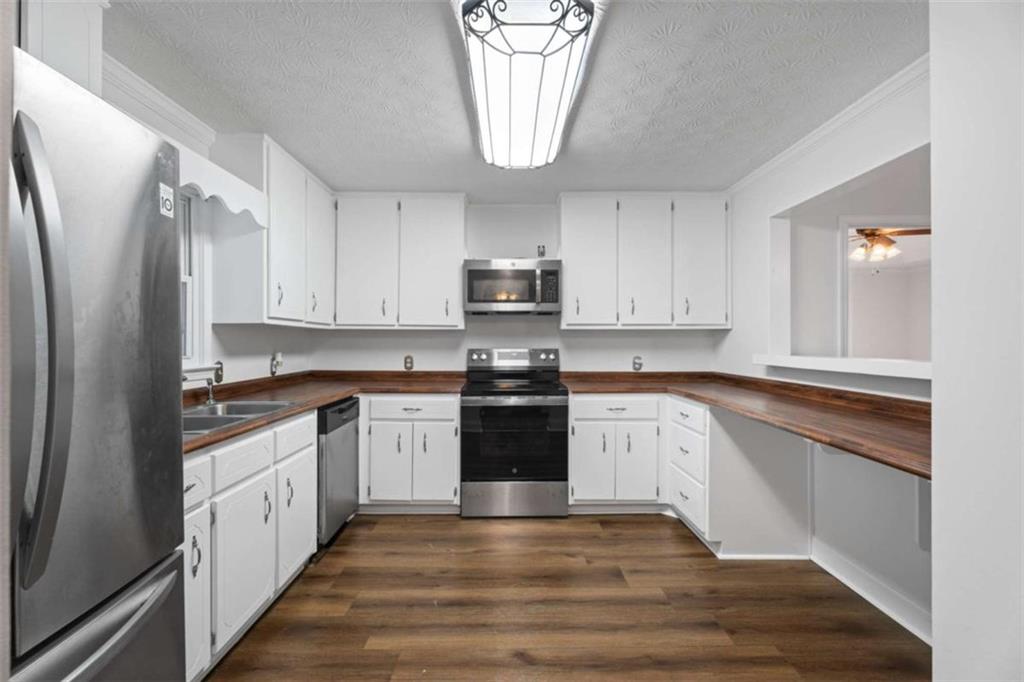 2284 Alcovy Station Road Covington, GA 30014 - Photo 11 of 45 a kitchen with granite countertop white cabinets and stainless steel appliances
