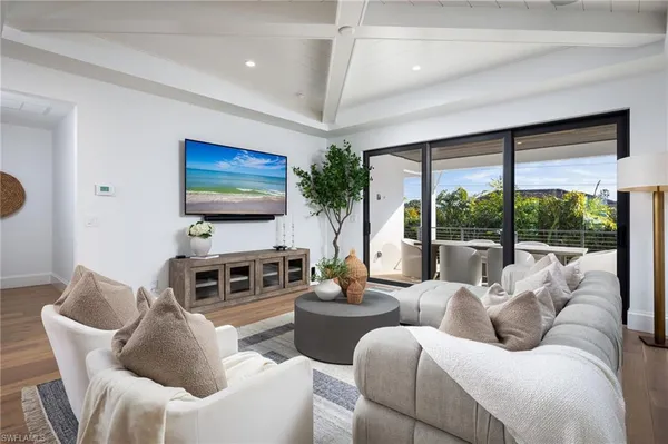 a living room with furniture a large window and a flat screen tv