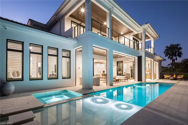 a view of a house with swimming pool and sitting area