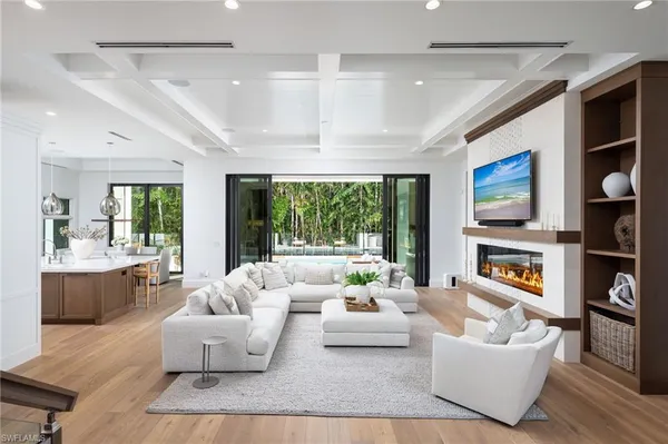 a living room with fireplace furniture and a large window
