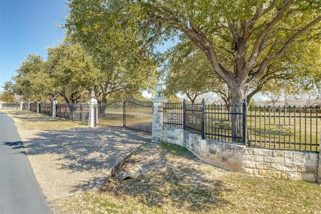 a view of a yard with wooden fence