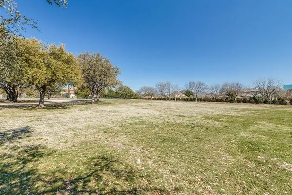 a view of water with lawn chairs and large trees