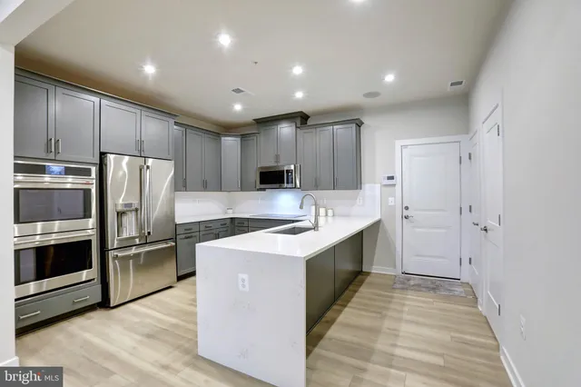 a kitchen with kitchen island granite countertop wooden cabinets and stainless steel appliances