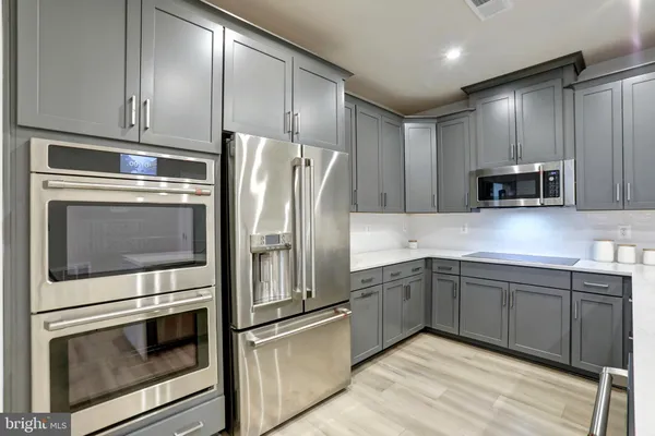 a kitchen with stainless steel appliances granite countertop a refrigerator and a stove top oven