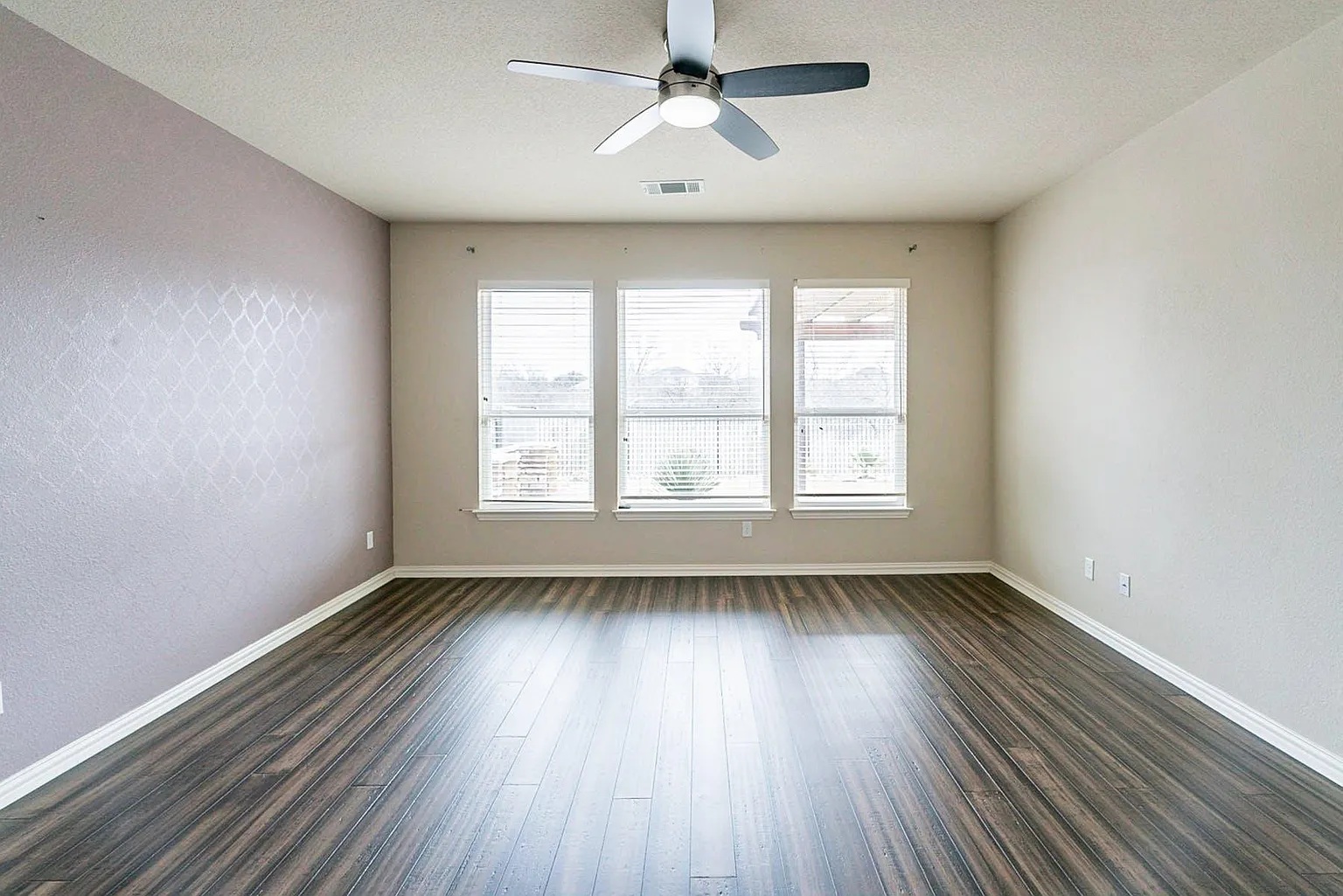 19717 Abigail Way Pflugerville, TX 78660 - Photo 3 of 9 an empty room with wooden floor chandelier fan and windows