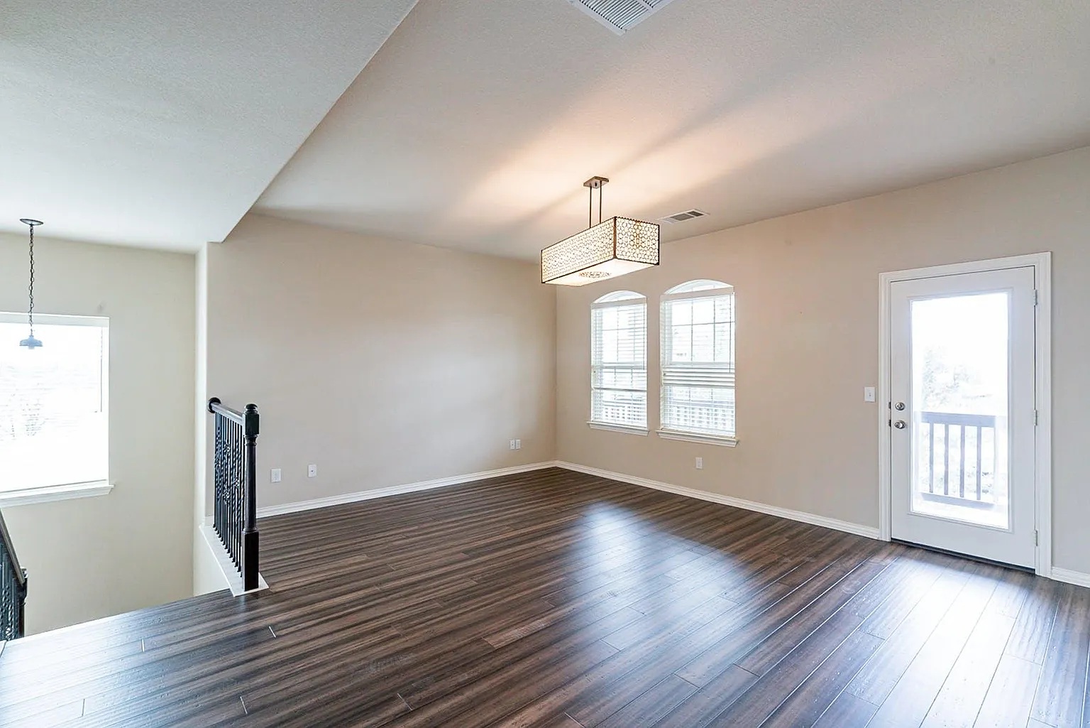 19717 Abigail Way Pflugerville, TX 78660 - Photo 9 of 9 an empty room with wooden floor chandelier and windows
