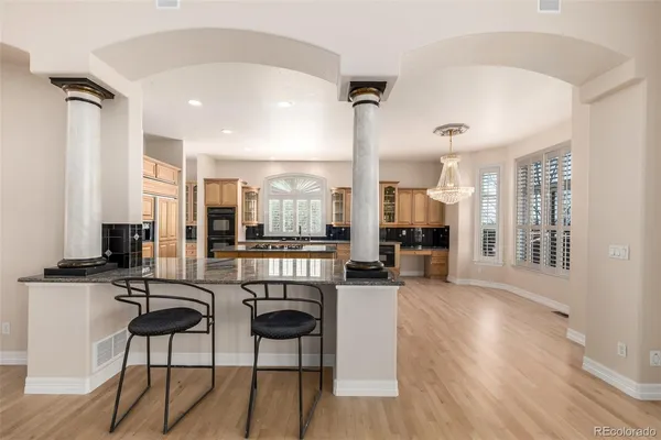 a living room with furniture a large window and wooden floor