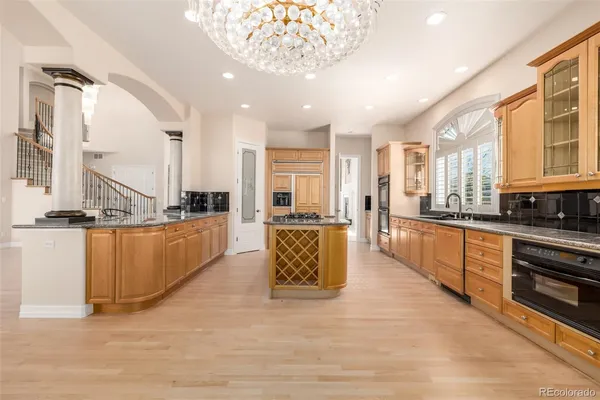 a large kitchen with kitchen island a large counter top space a sink stainless steel appliances and cabinets