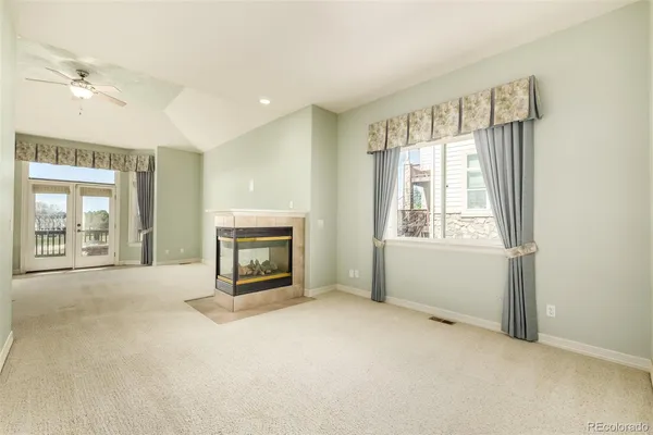 a view of an empty room with a fireplace and a window