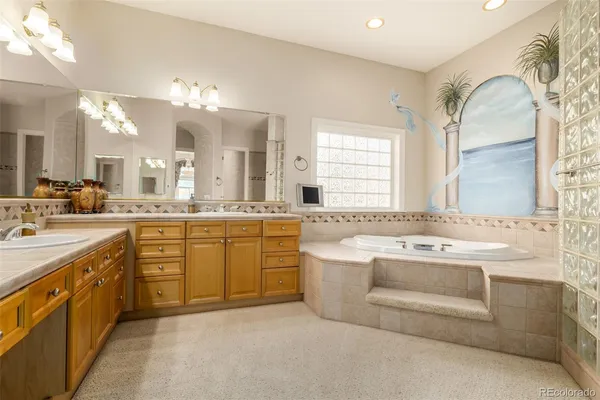 a spacious bathroom with a granite countertop double vanity and a mirror