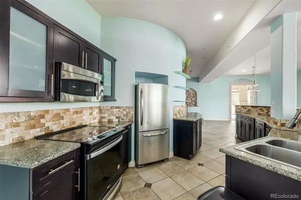 a kitchen with granite countertop a refrigerator and a sink