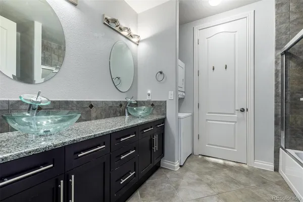 a bathroom with a granite countertop double vanity sink and a mirror