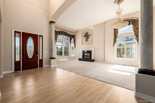 an empty room with windows fireplace and sink