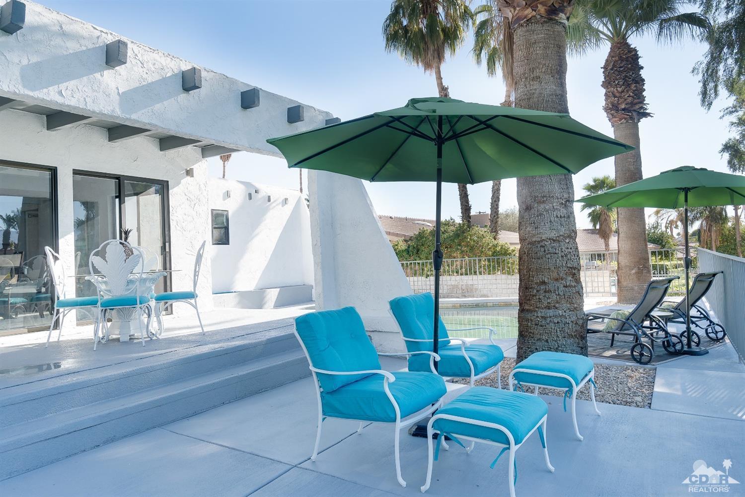 a view of an outdoor space with furniture and umbrella