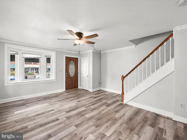 a view of an empty room with a window and a chandelier