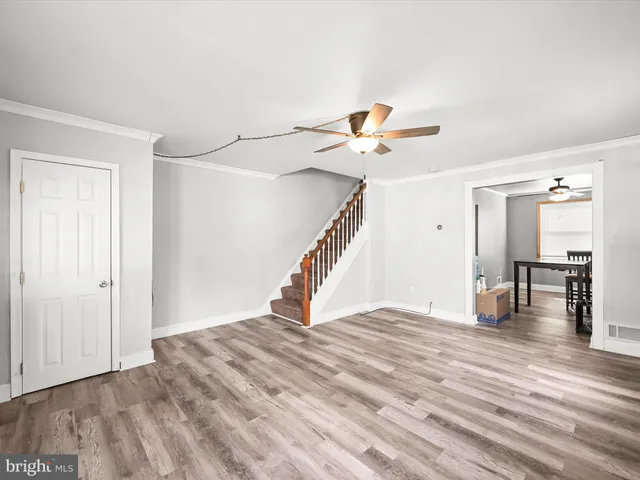 a view of a livingroom with wooden floor and a ceiling fan