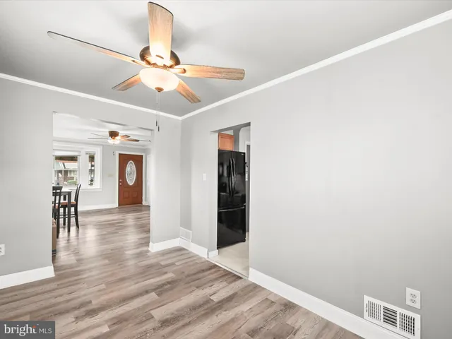 a view of a livingroom with wooden floor and a ceiling fan