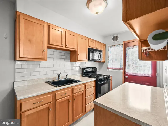 a kitchen with granite countertop a sink stainless steel appliances and cabinets