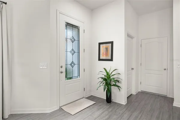 an empty room with wooden floor and a hallway