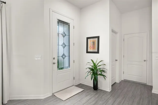 an empty room with wooden floor and a hallway