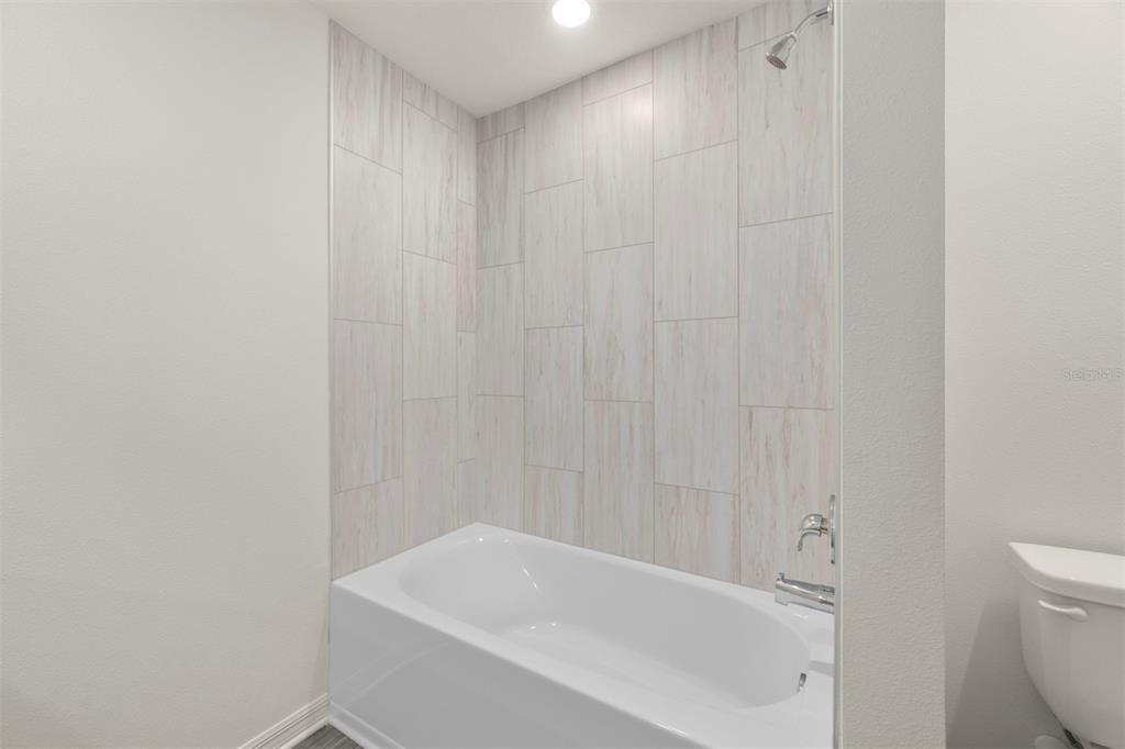 727 Poppy Lane Dundee, FL 33838 - Photo 22 of 31 a white bath tub sitting next to a white toilet and a shower