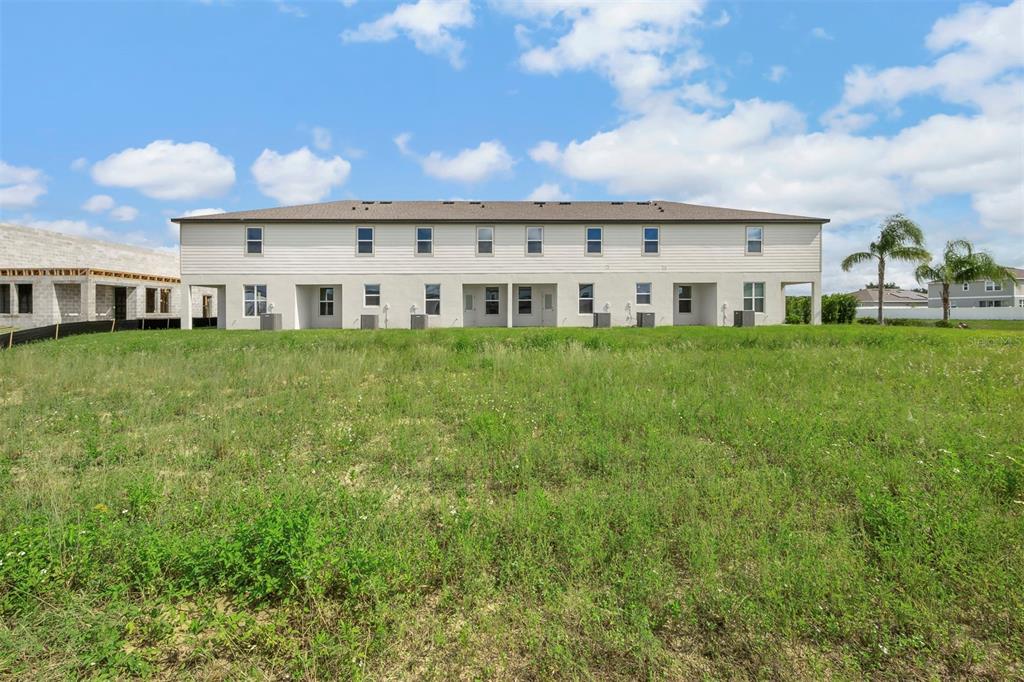 727 Poppy Lane Dundee, FL 33838 - Photo 31 of 31 a view of a white house with a big yard and large trees