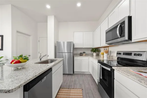 a kitchen with stainless steel appliances granite countertop a sink stove and refrigerator
