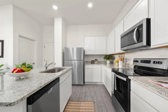 a kitchen with stainless steel appliances granite countertop a sink stove and refrigerator