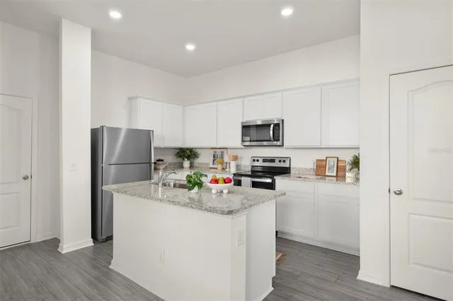 a kitchen with stainless steel appliances a refrigerator stove microwave and sink