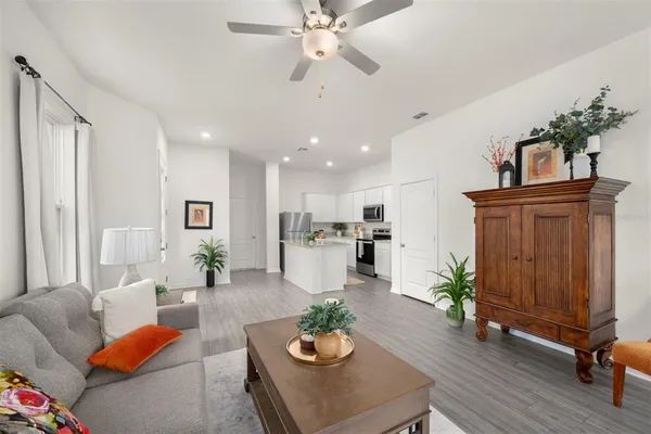 a living room with furniture kitchen view and a potted plant