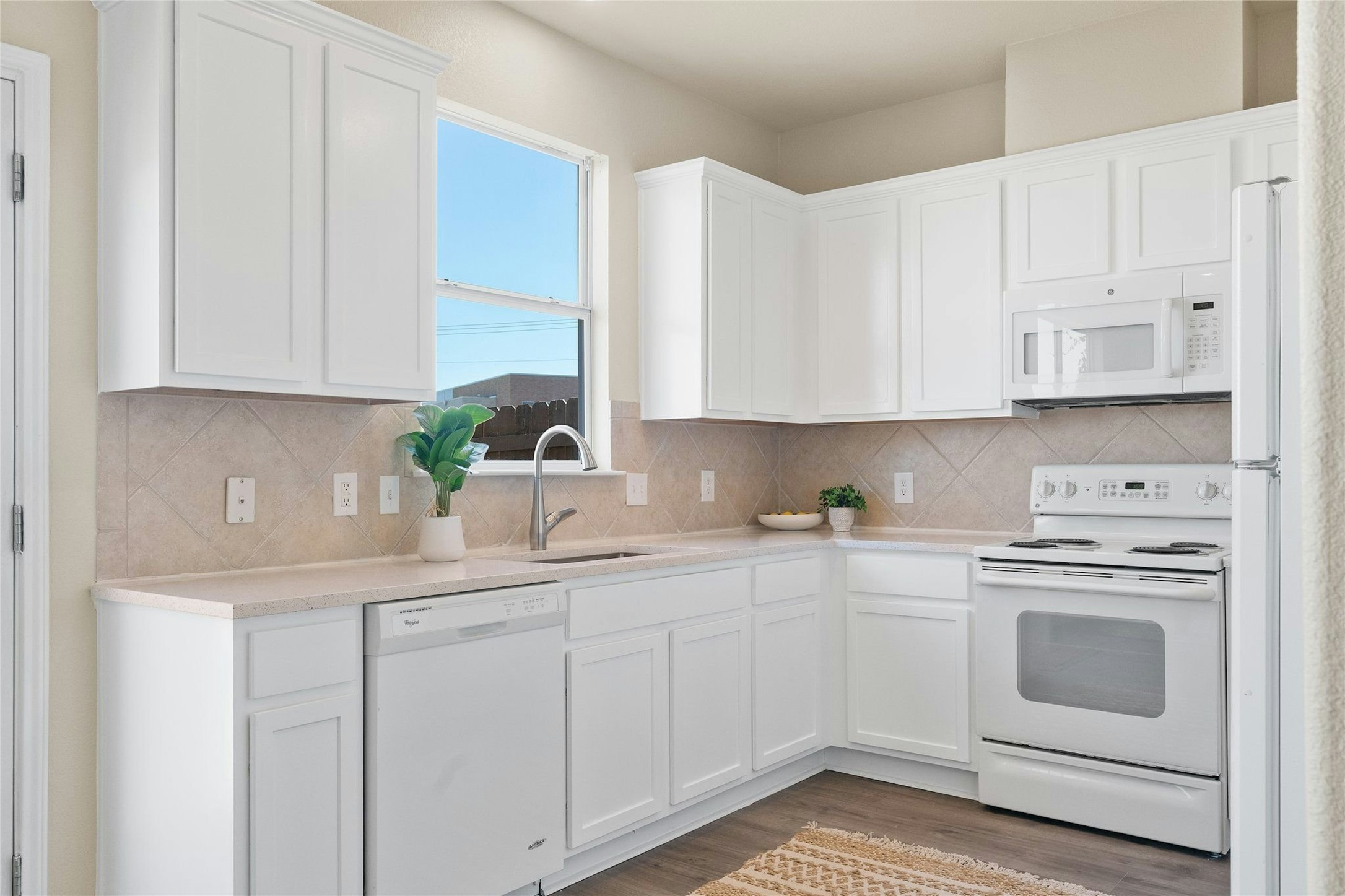 44 Verde Ranch Loop Leander, TX 78641 - Photo 9 of 24 a kitchen with white cabinets and white appliances