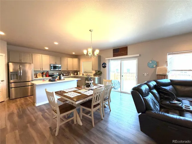 a dining room with furniture a kitchen view and a refrigerator