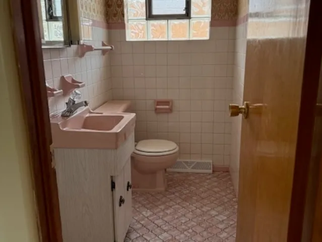 a bathroom with a toilet sink and mirror