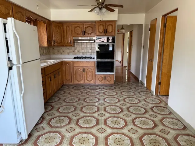 a kitchen with granite countertop a refrigerator and a sink