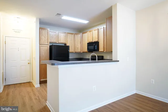a view of a kitchen with a refrigerator a microwave and a sink
