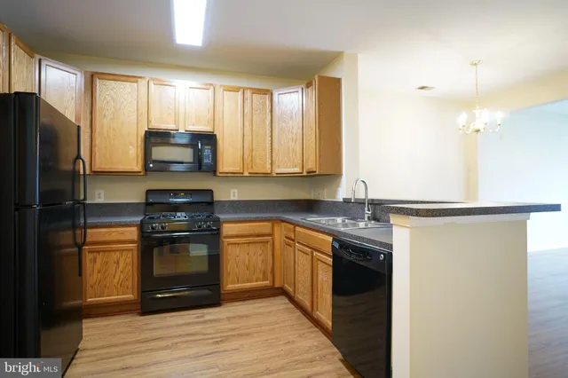 a kitchen with stainless steel appliances granite countertop a refrigerator stove top oven and sink