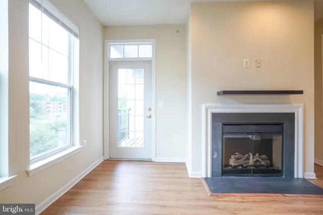 a view of an empty room with window and fireplace