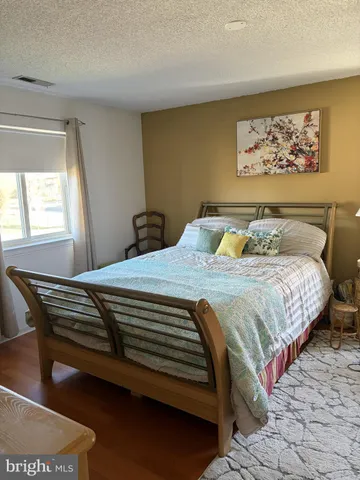 a bedroom with a bed and painting on the wall