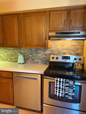a kitchen with wooden cabinets and a stove top oven