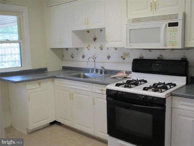 5900 Hillen Road Baltimore, MD 21239 - Photo 2 of 11 a kitchen with white cabinets and appliances
