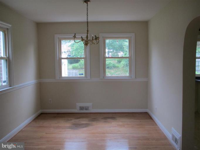 5900 Hillen Road Baltimore, MD 21239 - Photo 3 of 11 an empty room with wooden floor and windows