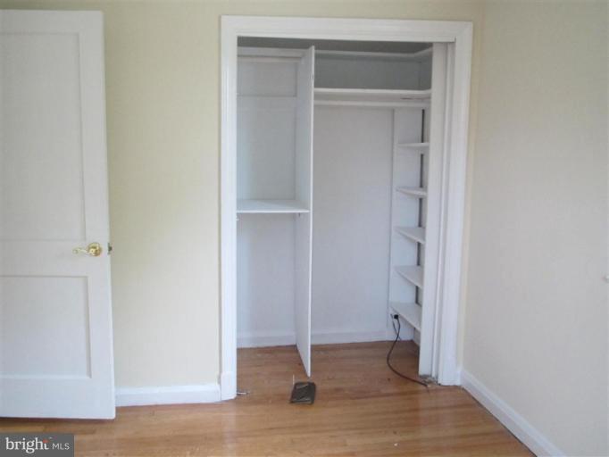 5900 Hillen Road Baltimore, MD 21239 - Photo 6 of 11 a view of an empty room with wooden floor and closet