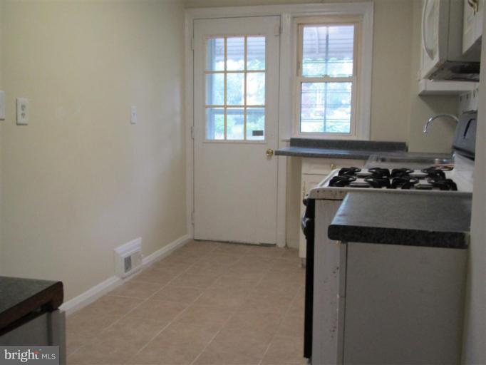 5900 Hillen Road Baltimore, MD 21239 - Photo 7 of 11 a kitchen with a stove a sink and a window