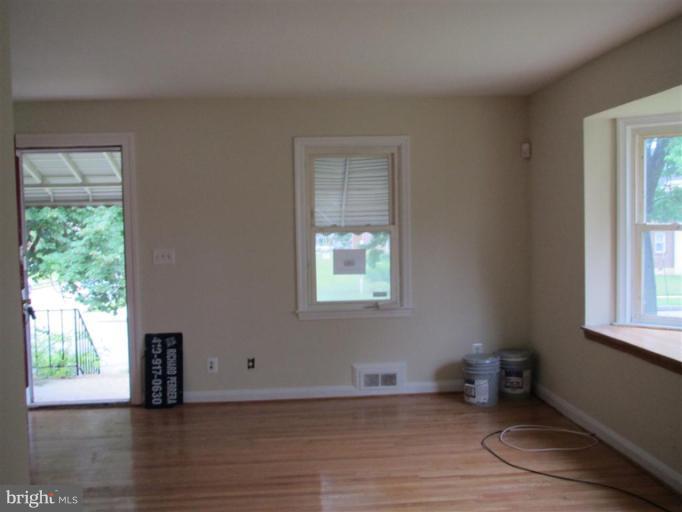 5900 Hillen Road Baltimore, MD 21239 - Photo 8 of 11 a view of an empty room with wooden floor and a window