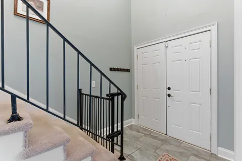a view of staircase with railing and white walls
