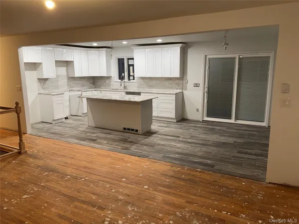 a large kitchen with a sink stainless steel appliances and cabinets
