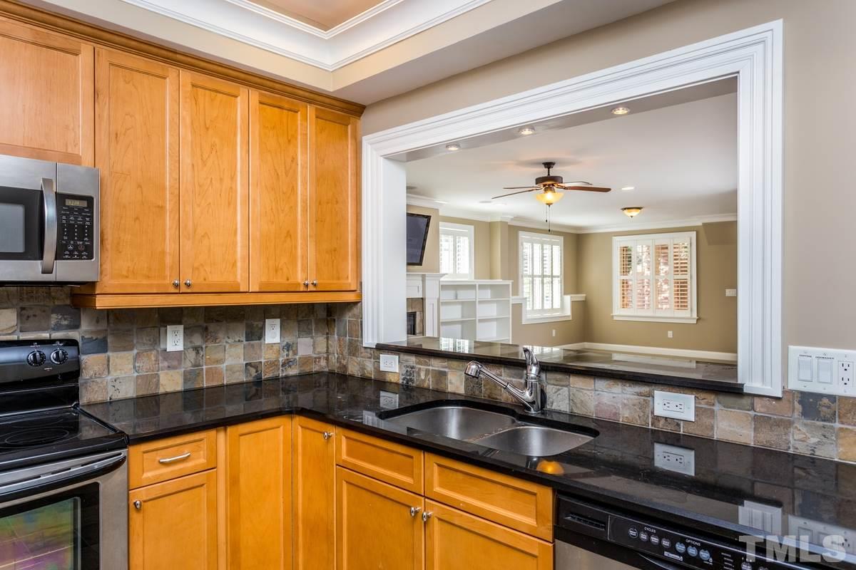 1300 Dixie Trail Raleigh, NC 27607 - Photo 21 of 24 a kitchen with granite countertop a sink stainless steel appliances cabinets and a counter top space